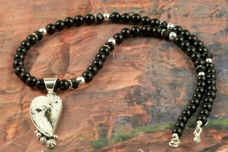 Genuine White Buffalo Turquoise set in Sterling Silver Pendant on a Genuine Black Onyx Necklace with Sterling Silver Beads and Clasp. This Beautiful Stone is formed from the minerals Calcite and Iron. It is mined near Tonopah Nevada. Created by Navajo Artist Lucy Valencia. Signed L. J.  by the artist.